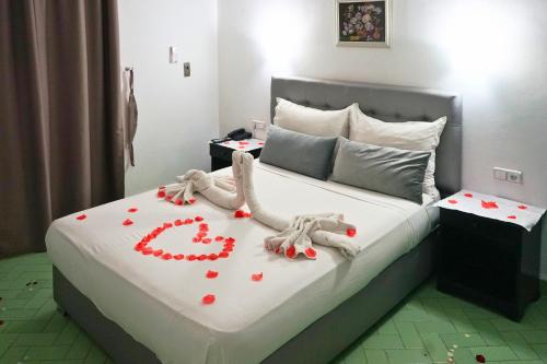 a bedroom with a bed with red hearts on it at Hotel Nouzha in Fès