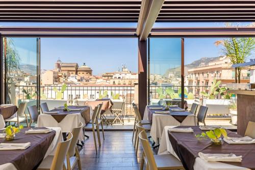un restaurant avec des tables et une vue sur la ville dans l'établissement PALAZZO SANTAMARINA Luxury Suite & Spa, à Palerme