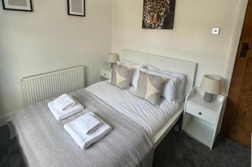 a bedroom with a bed with white sheets and pillows at Simonside Apartment - Sleeps 6 - Pets Ok - Parking in Newcastle upon Tyne