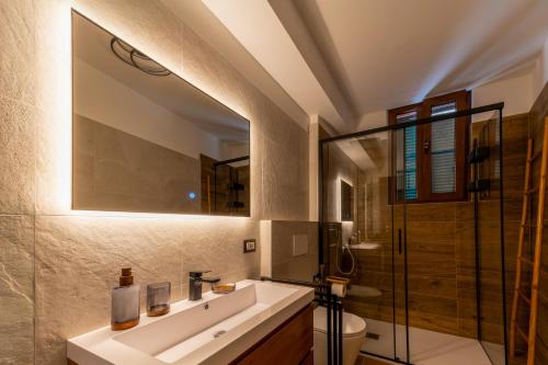 a bathroom with a sink and a glass shower at Ina's Lake Garden Nicolas Suite in Lenno
