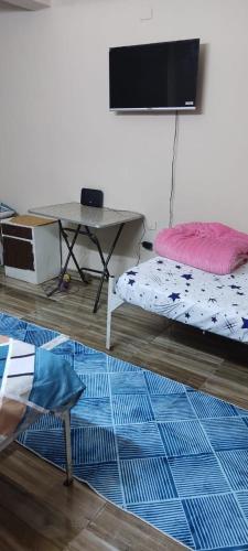 a room with a tv and a bed and a table at شقة مميزة بجوار كورنيش النيل اسوان - عائلات فقط in Aswan
