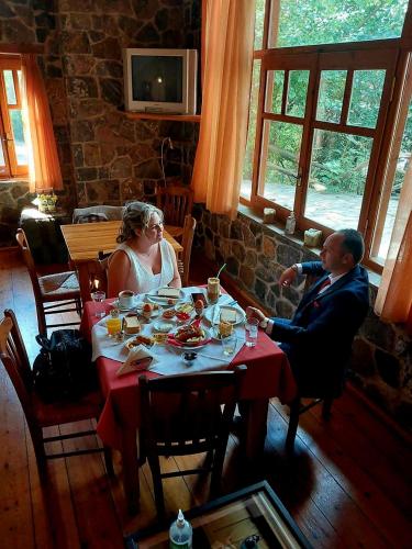 a man and woman sitting at a table in a restaurant at Hotel Semeli in Goura