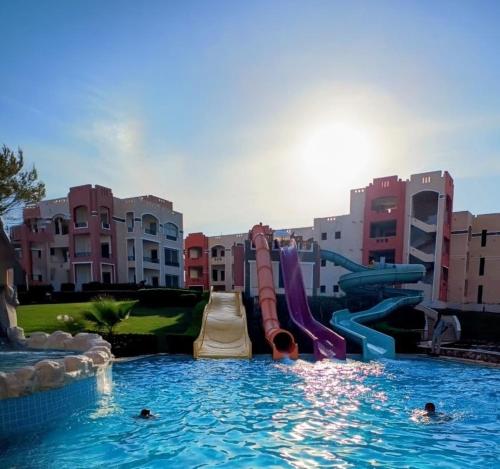 a pool with a water slide in a resort at Oyster Bay Beach suits in Marsa Alam