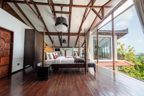 a bedroom with a bed and a large window at Paradise Island Estate in Choeng Mon Beach
