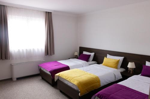 サラエボにあるMotel "Izvor Bosne"のベッドが2つと窓があるホテルの部屋