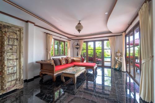 a living room with a couch and a table at Paradise Island Estate in Choeng Mon Beach