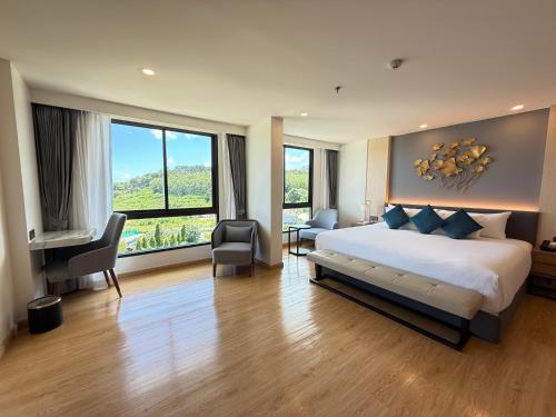 a bedroom with a large bed and a large window at Wyndham La Vita Rawai Phuket in Rawai Beach