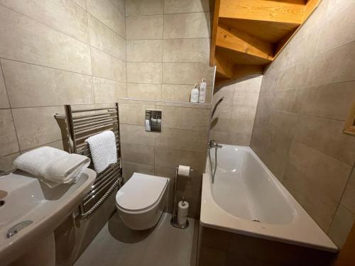 une salle de bain avec toilettes, lavabo et baignoire dans l'établissement Chalet Chocolat Chatel, à Châtel