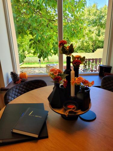 a table with flowers in vases on a table with a window at Kastély Ház in Sály