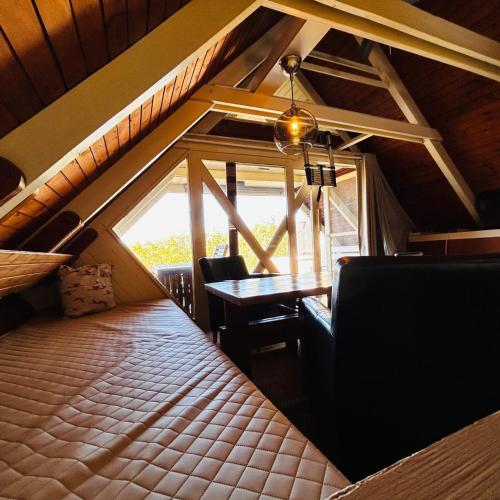 a room with a bed and a table and a window at Pfahlbau Sunset I Toplage Elektroboot inklusive in Rust