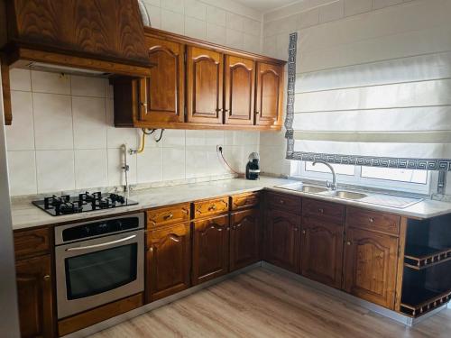 a kitchen with wooden cabinets and a stove top oven at Lar do Sossego in Geme