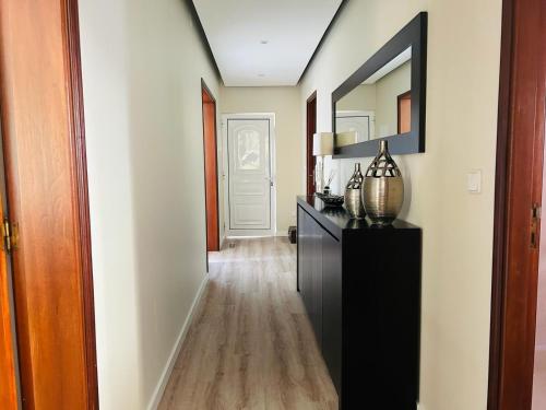 a hallway with a black dresser and a mirror at Lar do Sossego in Geme