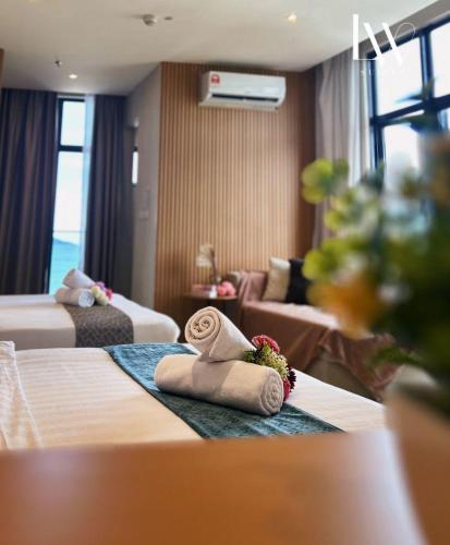 a hotel room with two beds with towels on them at The Shore Kota Kinabalu City Centre by LW Suites in Kota Kinabalu