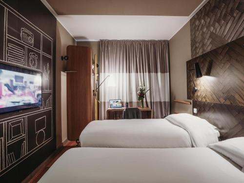 a hotel room with two beds and a flat screen tv at Ibis Casablanca City Center in Casablanca