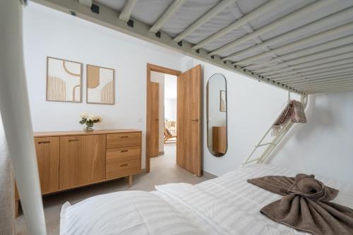 a bedroom with a white bed and a wooden dresser at Luxury Villa - Sunset Rooftop - Heated Pool - Outdoor Kitchen - Airconditioned in Palm-Mar