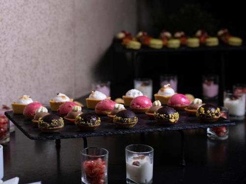 a table topped with different types of pastries and candles at Ibis Casablanca City Center in Casablanca