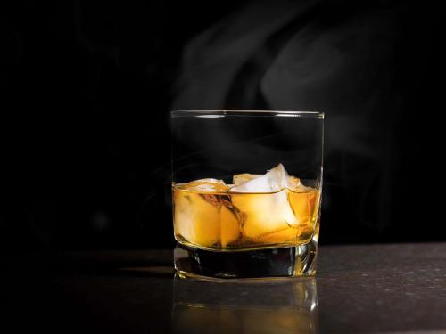 a glass of whiskey with ice on a table at Ibis Casablanca City Center in Casablanca