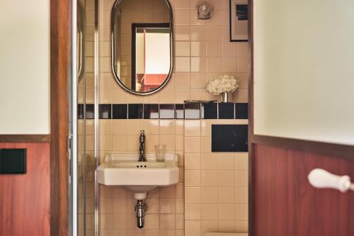 a bathroom with a sink and a mirror at Hôtel Marguerite in Paris