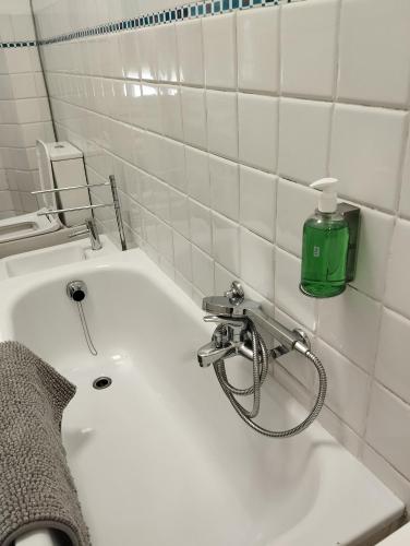 a white sink in a bathroom with a green bottle at LA LANTERNA DI ANGELO rent rooms and apartments free parking on the street front in Genova