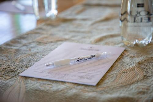 a pen sitting on top of a piece of paper on a table at Zevenwacht Country Inn in Kuilsrivier