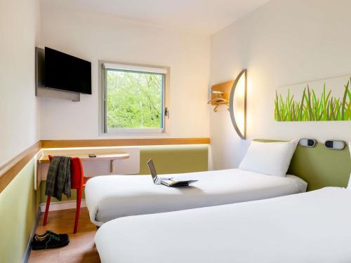 a hotel room with two beds and a window at ibis budget Derby in Derby
