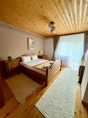 a bedroom with a bed and a wooden ceiling at Luna House Busteni in Buşteni