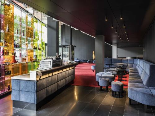 a restaurant with a bar with stools and tables at SO/ Vienna in Vienna