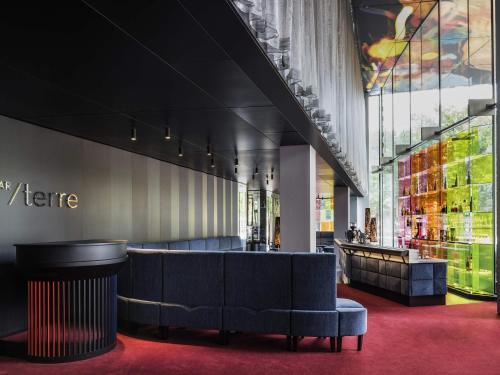 a lobby with a blue couch and a bar at SO/ Vienna in Vienna