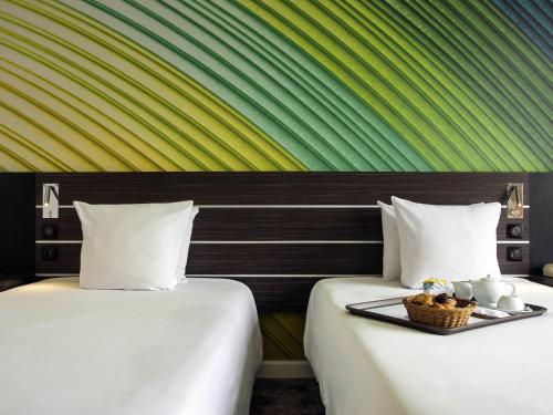 two beds with a tray of food on top of them at Novotel Cairo El Borg in Cairo