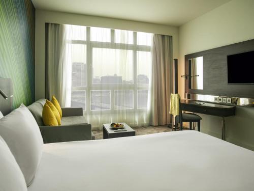 a hotel room with a large bed and a desk at Novotel Cairo El Borg in Cairo