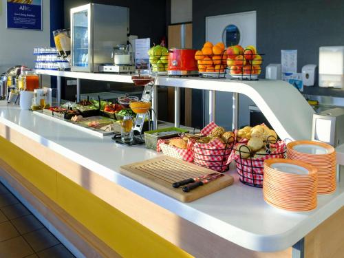 a buffet line in a restaurant with fruits and vegetables at ibis budget Katowice Centrum in Katowice