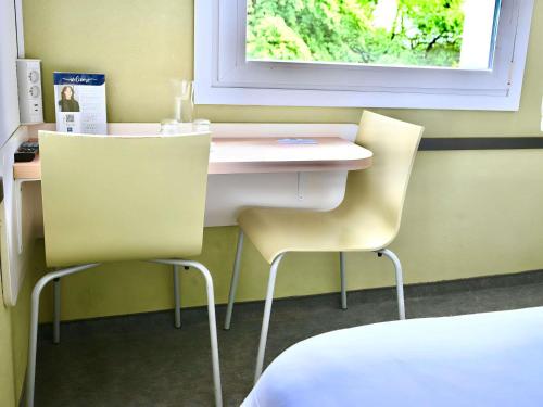 a room with two chairs and a desk and a window at ibis budget Wrocław Stadion in Wrocław