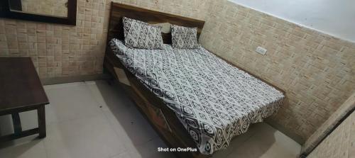 a bed in a room with a brick wall at Atharv Lodge in Katra