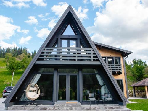 a frame house with a black roof at Cabana VeMont in Petru Vodă