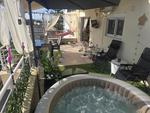 a hot tub in a backyard with an umbrella at Delphitea Philoxenia in Itea