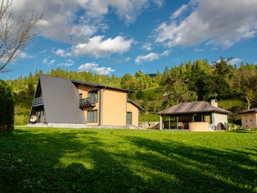 a house in a field with a green yard at Cabana VeMont in Petru Vodă