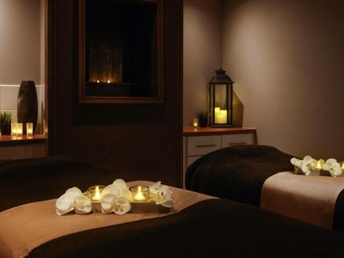 a hotel room with two beds with candles on them at Mercure Blackburn Dunkenhalgh Hotel & Spa in Blackburn