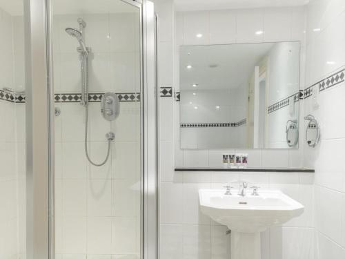 a white bathroom with a shower and a sink at Mercure Blackburn Dunkenhalgh Hotel & Spa in Blackburn