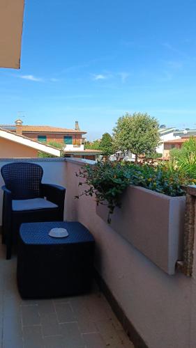 a bench and chairs on a balcony with plants at ROSSI SUITE Fco in Isola Sacra