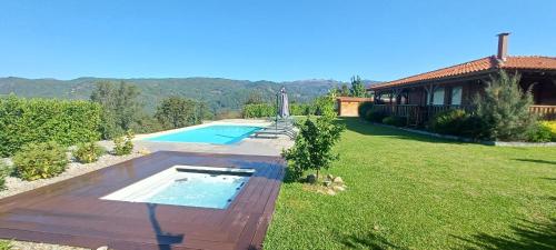 a backyard with a swimming pool and a house at Casa da Moda - Turismo de Campo in Vieira do Minho