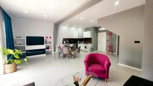 una sala de estar con una silla rosa y una mesa. en Magnika, en Sapareva Banya