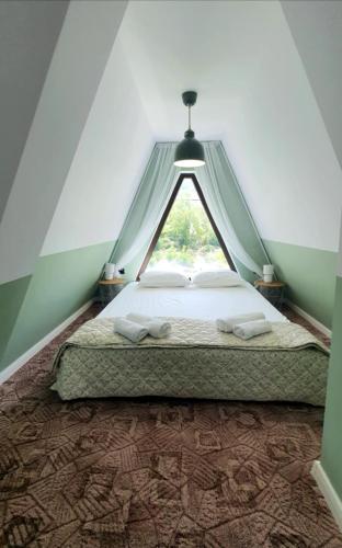 a bedroom with a bed with a triangular window at Magnika in Sapareva Banya