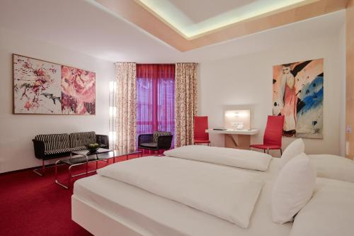 a bedroom with two beds and a table and chairs at Mintrops Land Hotel Burgaltendorf in Essen