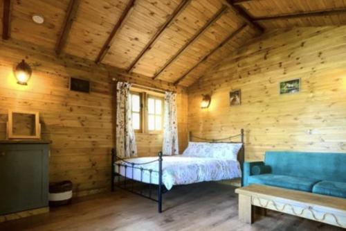 a bedroom in a log cabin with a bed and a couch at Inviting 1-Bed Cabin in Newmarket in Newmarket