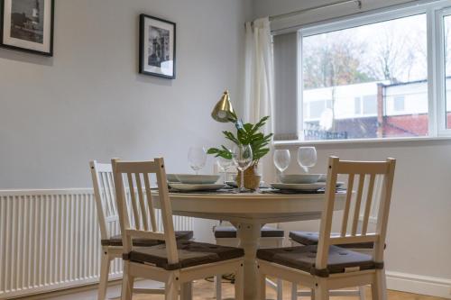 a dining room table with two chairs and a window at Howick House-Sleeps 5-Pet friendly-Parking-Garden in Newcastle upon Tyne