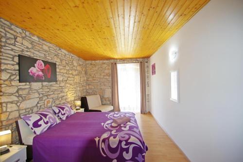 ŠajiniにあるHouse Gracijela, village Bulićiの石壁のベッドルーム(紫色のベッド1台付)
