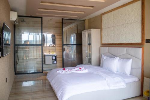 a bedroom with a large white bed in a room at Xcape Beach Club in Cape Coast
