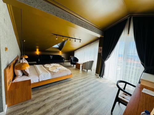 a bedroom with a large bed and a large window at Treekos Suite Hotel Istanbul Airport in Arnavutköy