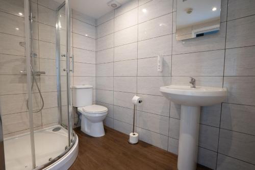 a bathroom with a sink and a toilet and a shower at Millstone Country Inn in Hathersage
