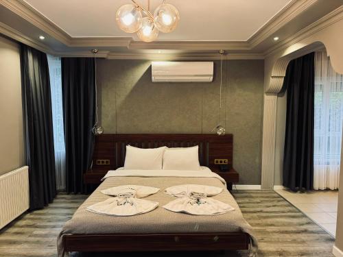 a bedroom with a bed with two towels on it at Treekos Suite Hotel Istanbul Airport in Arnavutköy